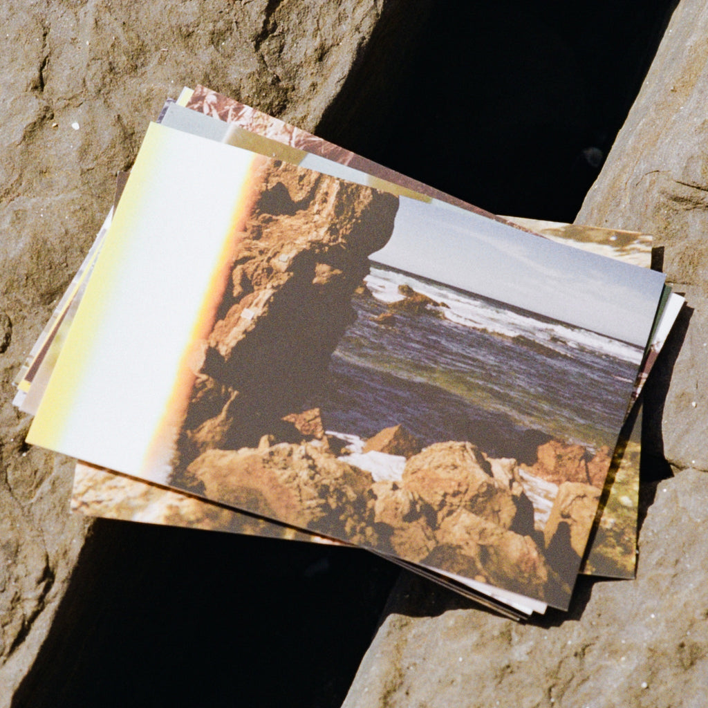 Coast Cards postcard held up at the beach